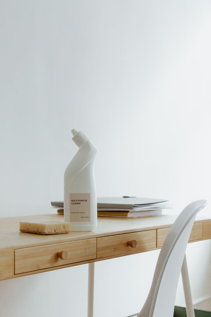 journey A clean and organized home office desk with a cleaner bottle and sponge, emphasizing simplicity and functionality.