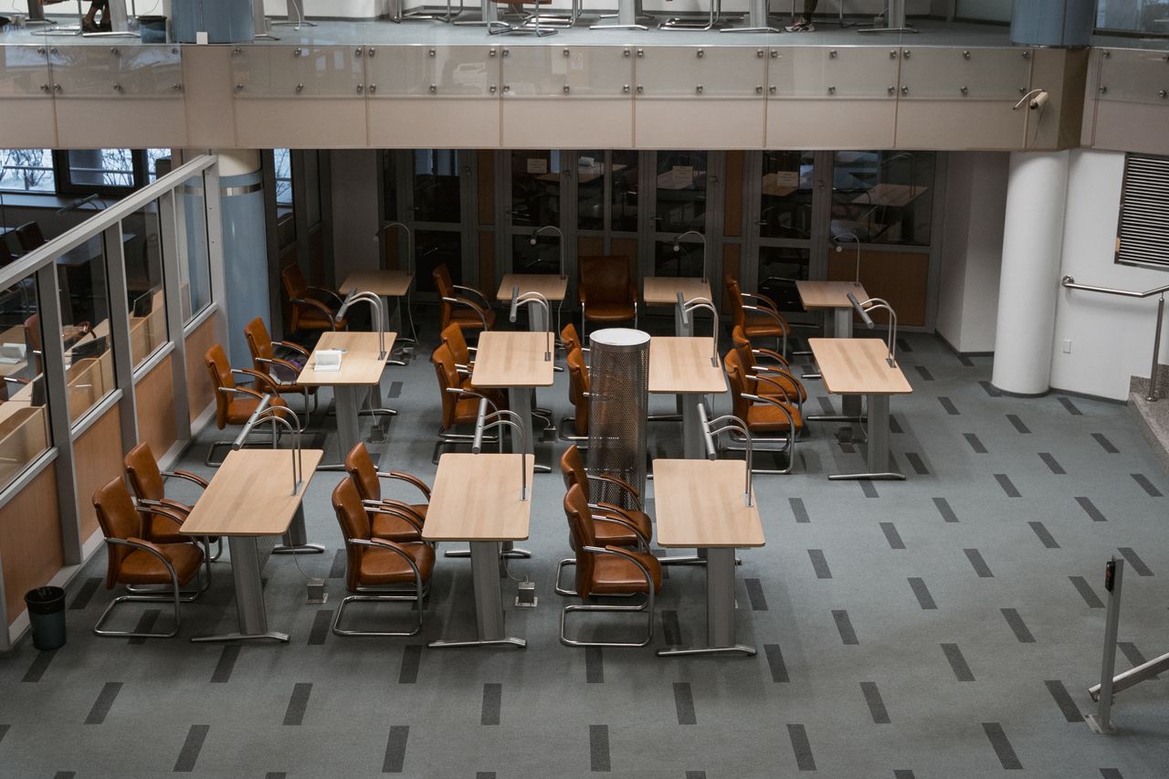 services-03 Bright, modern office interior with arranged chairs and tables, ideal for workspaces.